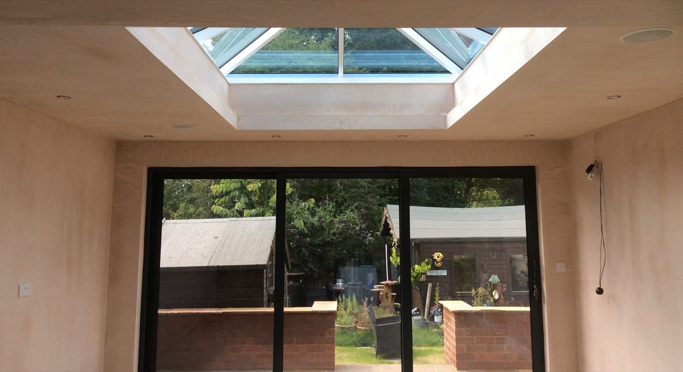 Inside a new extension: a roof lantern above and sliding doors onto the garden